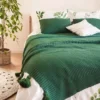 zielona narzuta z frędzlami do sypialni