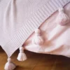 różowa narzuta na łóżko z frędzlami detal