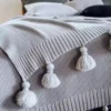 szara narzuta na łóżko z frędzlami ozdoba do salonu
