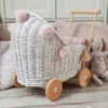 wózek wiklinowy dla lalek biały z różowymi pomponami pomysł na prezent